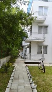 a bike parked in front of a white building at Lurd Family Hotel in Lozenets