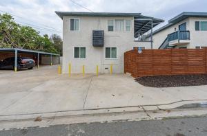 a building with a fence next to a parking lot at Central San Diego 2 BED Condo in San Diego