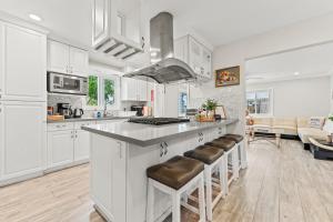 a kitchen with white cabinets and a counter with bar stools at Peaceful Home Near Beach & Disneyland in Huntington Beach