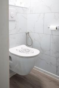 a bathroom with a toilet with graffiti on it at Corgi-Flowerhuisje in Lanaken +11 photos
