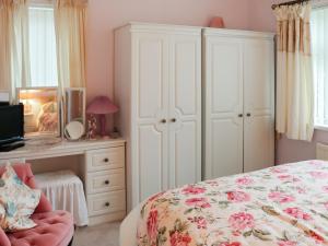 a bedroom with a bed and a desk with a dresser at Berllys - Uk48482 in Criccieth