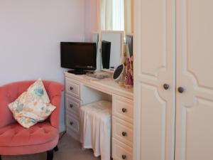 a bedroom with a desk with a computer and a chair at Berllys - Uk48482 in Criccieth