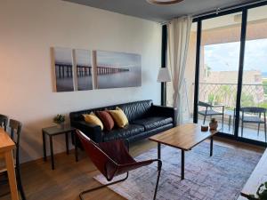 a living room with a black couch and a table at קיסריה נאות גולף- Oren Apartment in Caesarea