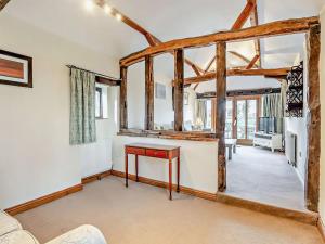 a living room with a table in a room with wooden beams at Pond View Cottage - Uk48230 in Tibenham