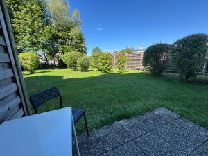 a table and a chair in a yard with a lawn at WuP Living Apartment am Stadtwald TG Parkplatz in Augsburg