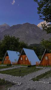 a couple of barns with mountains in the background at Fortyard Cottages Hunza in Karimabad Hunza