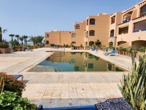 a swimming pool in the middle of a resort at Pieds dans l'eau in Agadir
