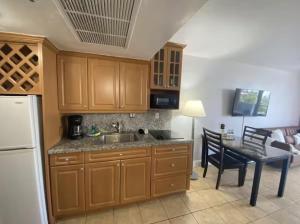 a kitchen with a sink and a table with a dining room at Pet Friendly Studio Beach and Pool Access, gym ! in Sunny Isles Beach