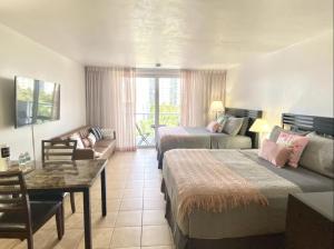 a hotel room with two beds and a couch at Pet Friendly Studio Beach and Pool Access, gym ! in Sunny Isles Beach