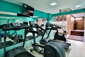 a gym with several tread machines in a room at Monte Serrat Hotel in Santos