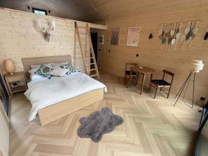 a bedroom with a bed and a wooden floor at Domki modułowe przy plaży in Sokole-Kuźnica