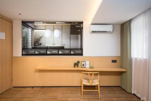 a chair in a room with a table and a mirror at SHI MO LI Hotel 诗茉莉酒店 in Shenzhen