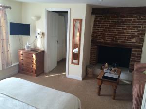 a bedroom with a bed and a brick fireplace at The Castle Inn in Bungay
