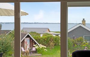 ファーボにあるLovely Home In Faaborg With Wifiの窓越しに庭を望む家