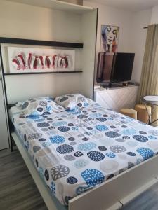 a bedroom with a bed with a blue and white comforter at le capitole in Fréjus