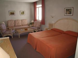 Un dormitorio con una cama, un sofá y una mesa. en Hotel San Jorge, en Alcalá de los Gazules