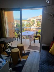 a room with a balcony with a table and chairs at le capitole in Fréjus