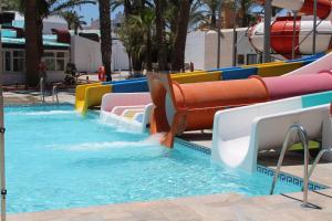 
a swimming pool filled with lots of water and lots of chairs at Playalinda Aquapark & Spa Hotel in Roquetas de Mar
