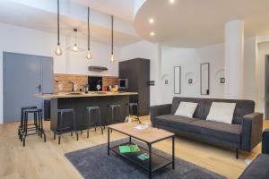 Una sala de estar con un sofá y una cocina. en 110 m2 loft-style apartment, en Burdeos