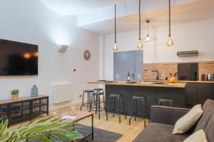 Una sala de estar con un sofá y una cocina. en 110 m2 loft-style apartment, en Burdeos