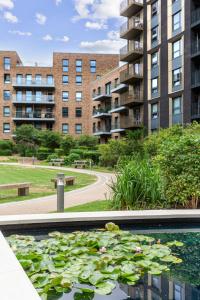 ロンドンにあるChic Luxury Apt Gym Balcony 5min to Stadium & Tubeの建物の前のユリの咲いた水たまり