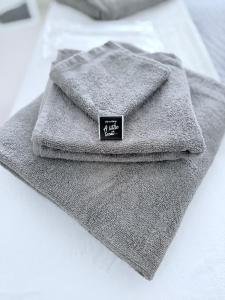 ロンドンにあるChic Luxury Apt Gym Balcony 5min to Stadium & Tubeのベッドの上に座った灰色のタオル