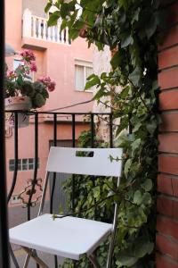 una silla blanca sentada en un balcón con flores en Hostal Amantes De Teruel, en Teruel