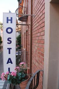 a sign on the side of a brick building with benches at Hostal Amantes De Teruel in Teruel