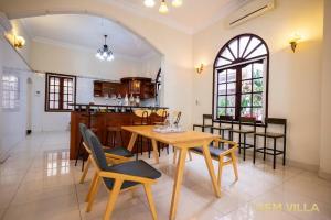 a dining room and kitchen with a table and chairs at Gem Villa 10 - 5 Big Bedroom Big Pool Big Garden in Ho Chi Minh City