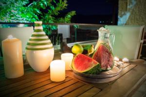 a table topped with a plate of watermelon and candles at Villa Christini in Kissamos