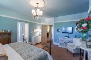 a bedroom with blue walls and a bed and a television at The Woodview Inn in Gananoque