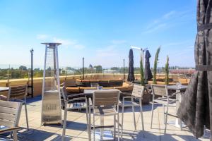 a patio with tables and chairs on a roof at Grand Legacy At The Park in Anaheim