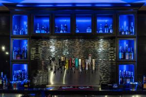 a bar with blue lights on a wall with bottles at Grand Legacy At The Park in Anaheim
