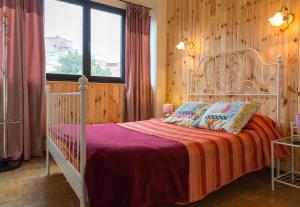 a bedroom with a white bed in a room with wooden walls at Pensión La Fruta in Avilés