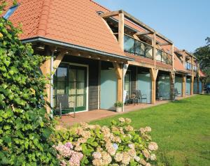 een huis met een terras met stoelen erop bij Hotel De Walvisvaarder in Lies