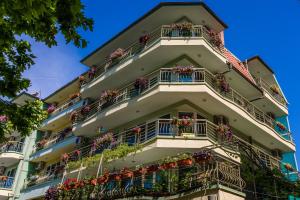 a tall apartment building with flower boxes on balconies at Guest House ,, Ekaterina" in Nesebar