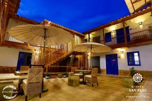 an outdoor dining area with tables, chairs and umbrellas at Quinta San Blas by Ananay Hotels in Cusco