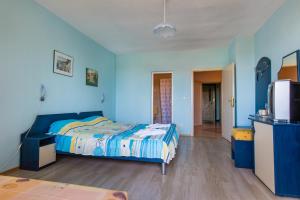 a blue bedroom with a bed and a tv at Guest House ,, Ekaterina" in Nesebar