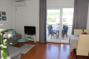 a living room with a couch and a television and a table at Anchor Apartments in Stari Grad