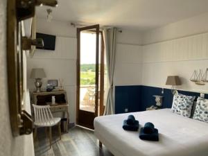 a bedroom with a bed with blue towels on it at Hôtel Bien-Être Aux Cyprès de Marquay in Marquay
