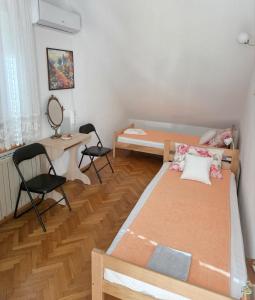 a small room with two beds and a desk at Vila Pjer Niska Banja in Niška Banja
