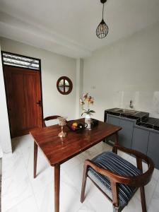 a kitchen with a wooden table and a wooden chair at Berlianohomestay2 in Jarakan