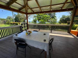 a table on a deck with two chairs at Lisi's ocean Breeze Escape in Welangi