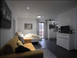 een woonkamer met een bank en een keuken bij Alpine Escape in Hopfgarten in Hopfgarten im Brixental