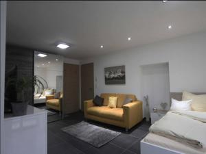 een slaapkamer met een bed en een bank en een woonkamer bij Alpine Escape in Hopfgarten in Hopfgarten im Brixental