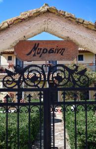 a sign on a gate in front of a building at Mirsini Apartments in Agios Georgios