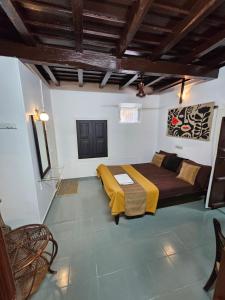 Un dormitorio con una cama y un sofá en una habitación. en Vrindavanam Avocado, en Alleppey