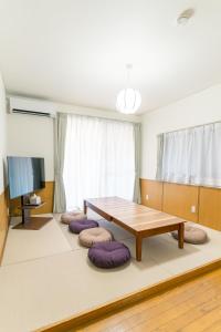 a living room with a wooden table and purple cushions at みらいステイ坪井 in Kumamoto