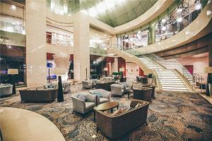 a lobby with couches and a staircase in a building at Beijing Marriott Hotel Northeast in Beijing