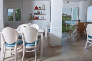 a dining room with white chairs and a table at 12 Olympian Gods in Platamonas